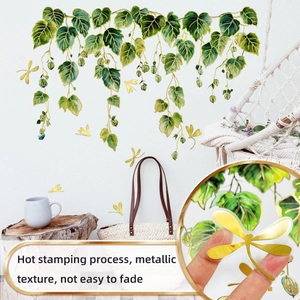 Detail showing hot stamping process on green vine wall decals with metallic golden dragonflies