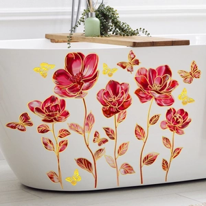 Detail of red floral and butterfly wall decals with gold outlines on a white bathtub