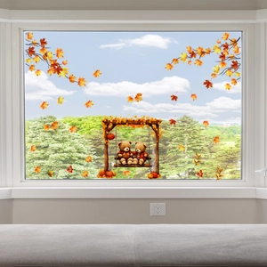Detail of autumn window clings featuring cute teddy bears on a swing with maple leaves