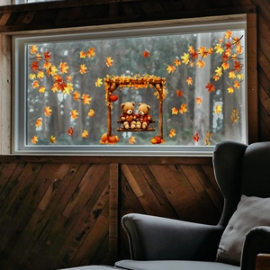 Detail of autumn window stickers featuring cartoon bears on a swing with maple leaves