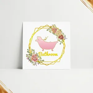 Self-adhesive bathroom wall decal featuring pink hippo, floral accents and gold frame
