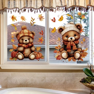 Detail of fall harvest window clings showing cute bears and autumn maple leaves on glass
