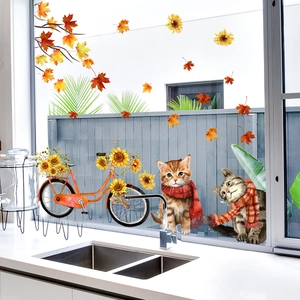 Detail of autumn window stickers with cats, orange bicycle, sunflowers and maple leaves