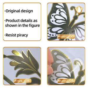 Macro detail of waterproof gold foil butterfly wall sticker with dark green floral accents