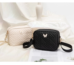 Detail of quilted leather crossbody bags with gold butterfly buckles and V-stitch patterns