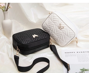 Detail of quilted camera bags with golden butterfly clasp and adjustable fabric strap