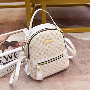 Eleganter weißer Mini-Rucksack mit gelbem Blumenmuster und goldenen Details auf Teppich
