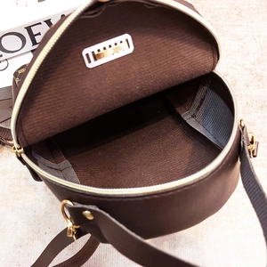 Brauner Monogramm-Rucksack mit offenem Reißverschluss und Blick in das Innenfach