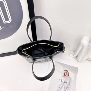 Borsa tote trapuntata nera con cerniera dorata e scomparto interno, vista dall'alto moderna