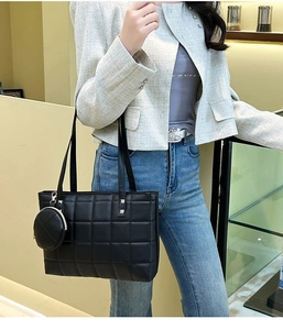 Close-up of black quilted checkered tote bag with a matching circular mini coin purse