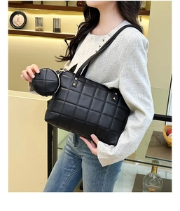 Close-up of black quilted tote bag with metal studs and detachable round coin purse