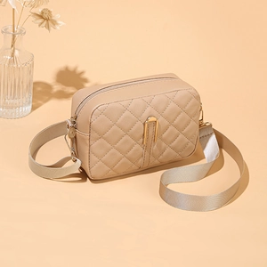 Dettaglio borsa a tracolla beige trapuntata con zip dorata e tracolla in tessuto