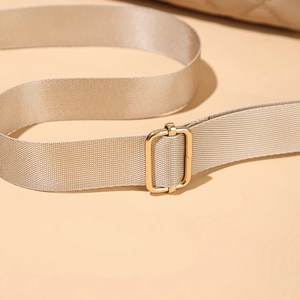 Dettaglio della tracolla per borsa in nylon beige con fibbia regolabile in metallo oro