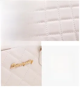 Detailed view of white quilted faux leather texture and polished golden metal hardware logo