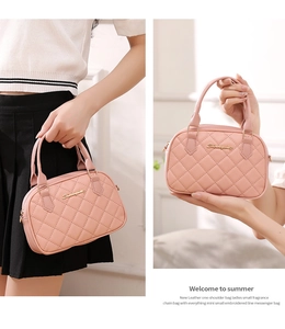 Close-up of pink quilted leather texture with gold metal logo and stitching details