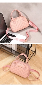Pink quilted shell bag featuring dual handles and a wide fabric shoulder strap