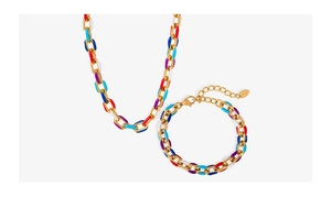 Detail von grober goldener Gliederkette mit buntem Emaille-Oval-Design