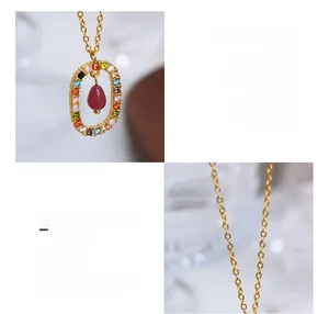 Detail of 18K gold plated titanium steel necklace with colorful crystals and red drop pendant