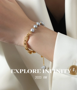 Detail of vintage gray pearl and gold braided chain bracelet worn on female wrist