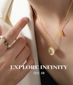Detail of gold plated daisy shell pendant necklace and colorful beaded ring on model