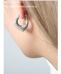 Close-up of minimalist silver irregular geometric earring with liquid metal mirror finish