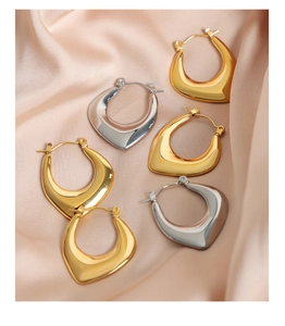 Detail of U-shaped geometric earrings in polished 18k gold and silver stainless steel