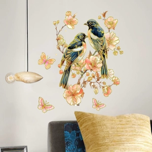 Floral wall decal with birds and golden butterflies on a minimalist white living room wall