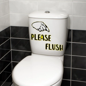 Detailed close-up of Please Flush gold foil sticker on a white ceramic toilet tank