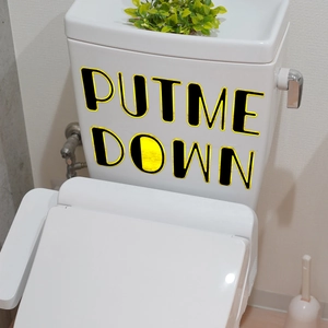 Detail of waterproof 'PUT ME DOWN' decal sticker applied to white ceramic toilet tank