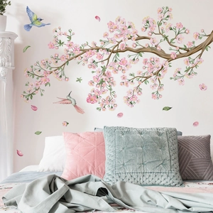 Wall decals featuring cherry blossom branches and flying birds in a cozy bedroom setting