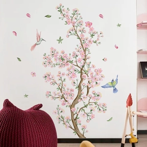 Pink cherry blossom wall decals with birds in a cozy bedroom nursery interior scene