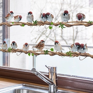 Vibrant sparrow and vine window stickers on a bright glass pane for home decoration