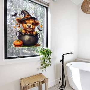Close-up of Highland cow Halloween window sticker on glass with pumpkin and bat motifs