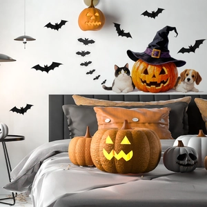 Halloween wall stickers featuring bats and pumpkins displayed above a bedroom bed
