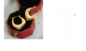 Polished gold plated U-shaped geometric earrings inside a luxury red jewelry gift box