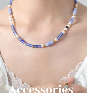 Détail d'un collier bohème avec calcédoine bleue, perles et perles dorées en acier