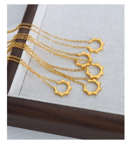 Vue détaillée de plusieurs colliers en U plaqués or sur un plateau en tissu blanc
