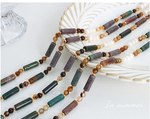 Détail d'un collier bohème fait main avec pierres naturelles, perles d'agate et de perles