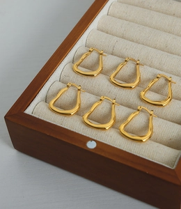 Detailansicht goldene Tropfenohrringe aus Titan mit 18k Vergoldung in einer Schmuckschatulle