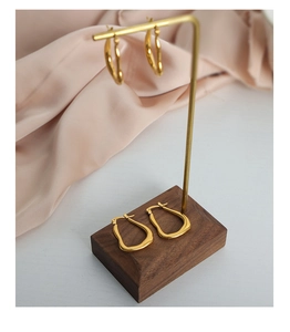 Detailansicht goldener unregelmäßiger geometrischer Ohrringe am Displayständer