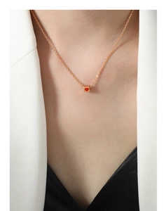 Close-up of a rose gold square pendant with a red heart on a minimalist chain necklace