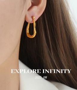 Detailansicht eleganter goldener Tropfenohrringe an einem Model im minimalistischen Stil