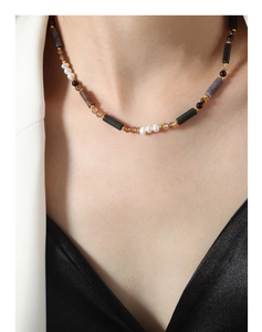 Détail d'un collier bohème en perles colorées et pierres naturelles sur le modèle