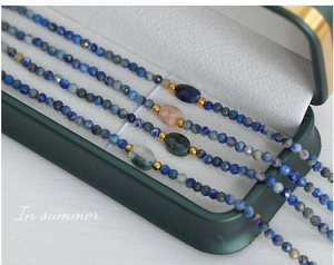 Detailed close-up of four handmade beaded necklaces with faceted natural gemstones and steel