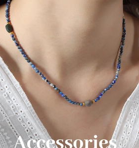 Close-up of handmade baroque necklace with blue natural stone beads and gold spacers