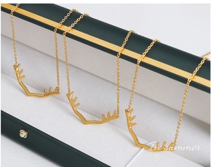 Détail macro de trois colliers bois de cerf dorés dans un écrin à bijoux de luxe