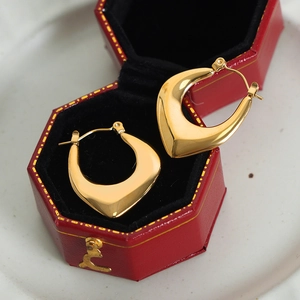 Elegant gold plated chunky U-shaped hoop earrings on luxury red velvet jewelry gift box