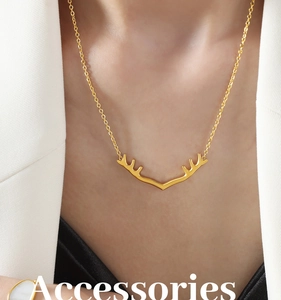 Gros plan du collier avec pendentif bois de cerf doré porté par un mannequin