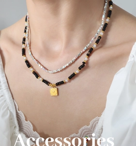 Detail of layered bohemian necklace with black onyx beads and a heart relief pendant