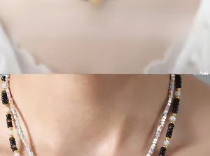 Detail of double-layered beaded necklace with black onyx beads and golden spacers
